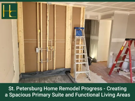 Interior wall framing with plumbing pipes and two ladders in a home under renovation